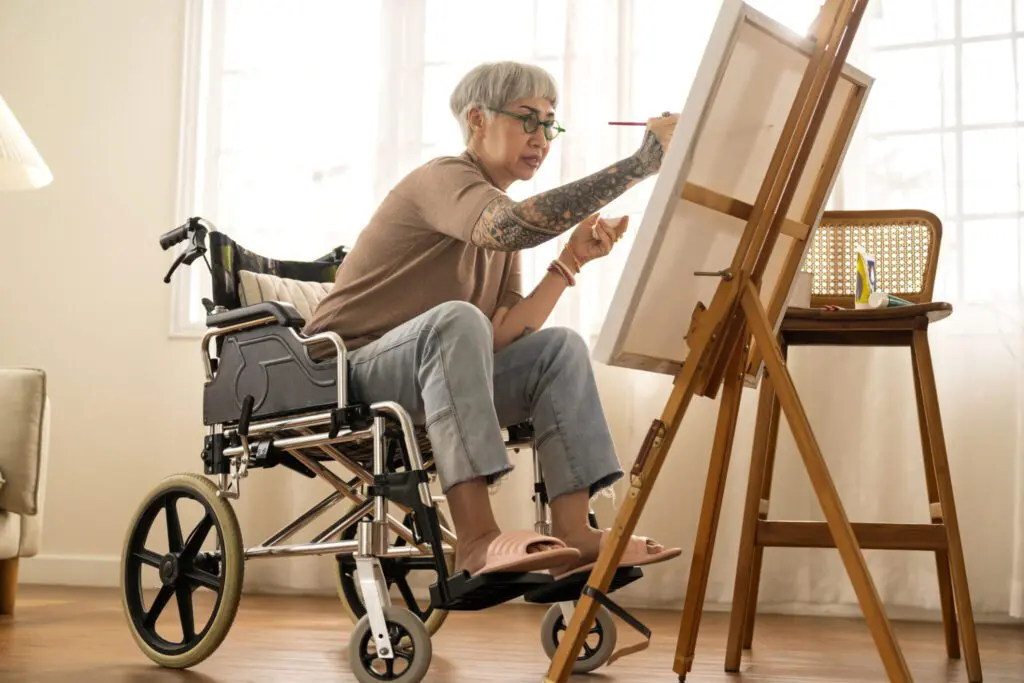 Senior female in wheelchair painting