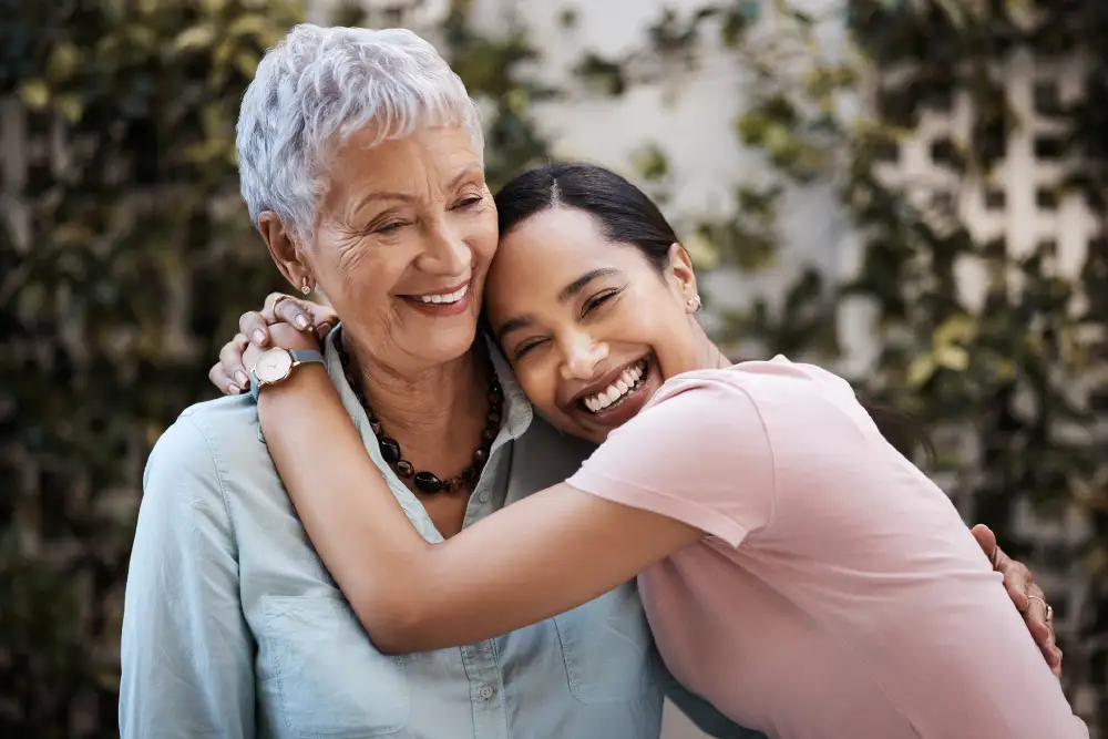 a senior woman and her adult daughter hugging
