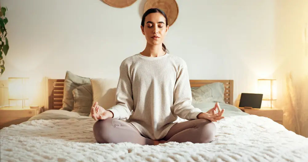 a family caregiver meditating on the bed