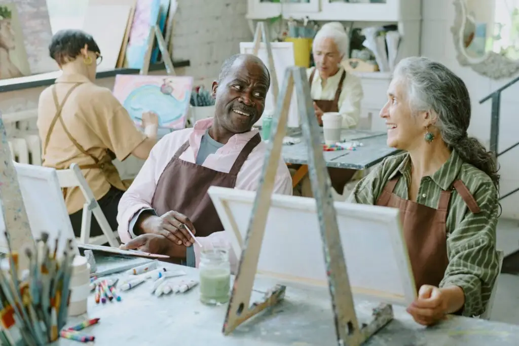 A group of older adults in art class. Read about resident artists demonstrating creativity.