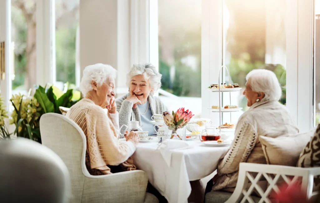 senior women having a tea party and discussing the benefits of assisted living