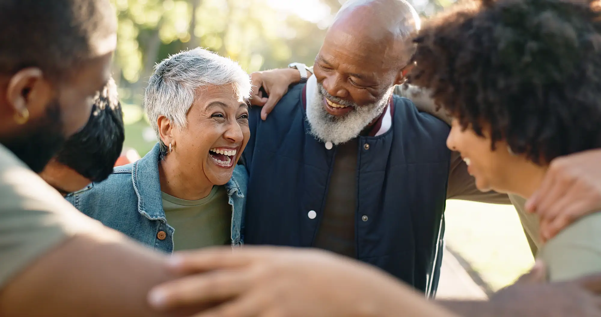 Senior couple laughing outdoors with friends