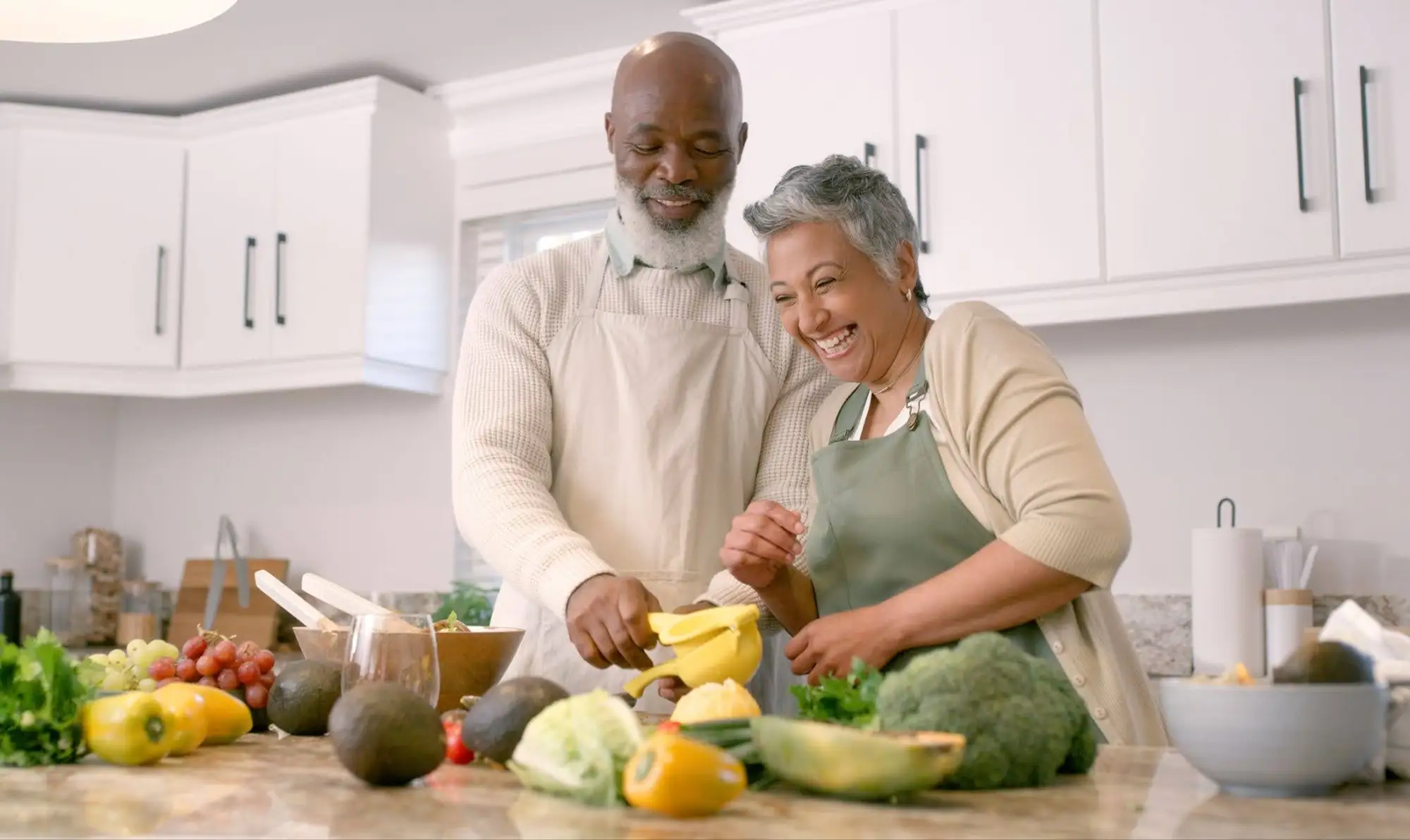 A senior couple making brain-boosting nutritious meals for seniors from the comfort of the independent senior apartment at Clarendale Clayton in MO.